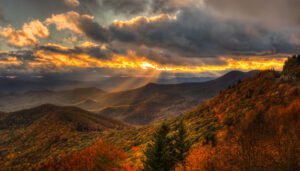 Autumn sunset over the Blue Ridge Parkway, highlighting vibrant fall foliage and scenic mountain views, perfect for attracting October travelers to Southeast communities.